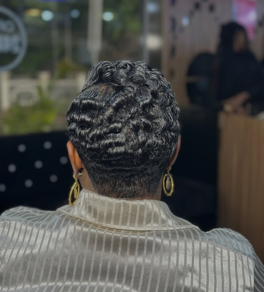 Back view of short sculpted finger waves with gold hoop earrings