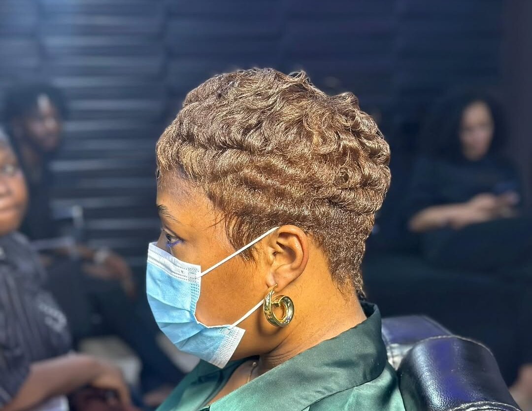 Side profile of a honey blonde pixie with soft curls
